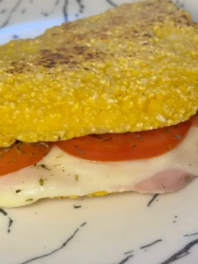 Aprenda a fazer Cuscuz de Frigideira recheado! Uma receita rápida, fácil e deliciosa, crocante por fora e macia por dentro. Perfeita para um lanche!